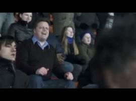 Jag agerar i huvudrollen som fotbollsentusiast. Jag lever mig in i spelet, så att jag tror att jag är på arenan. Men hustrun tar mig tillbaka till verkligheten.